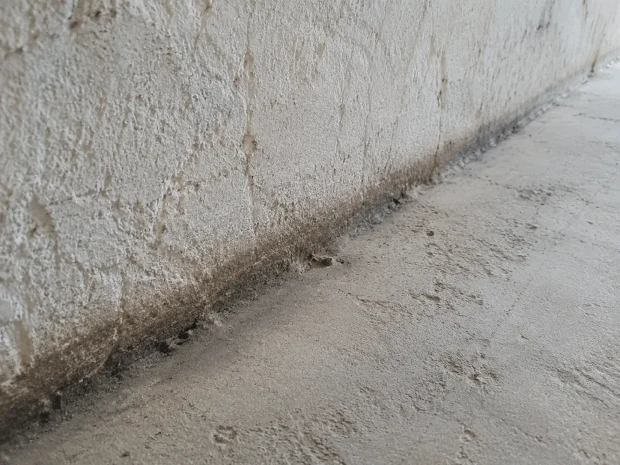 Dunkle Schmierspur entlang einer rauen Wandkante